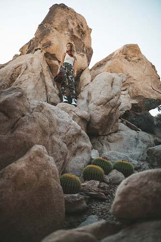 rock woman standing on rock formation near green cacti during daytime joshua tree